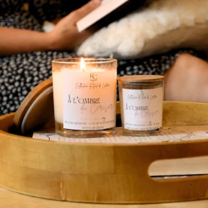 Bougie parfumée fleur de sakura À l’Ombre du Cerisier de RomanCirière allumée en format 200g, accompagnée du format 60g sur un plateau en bois.